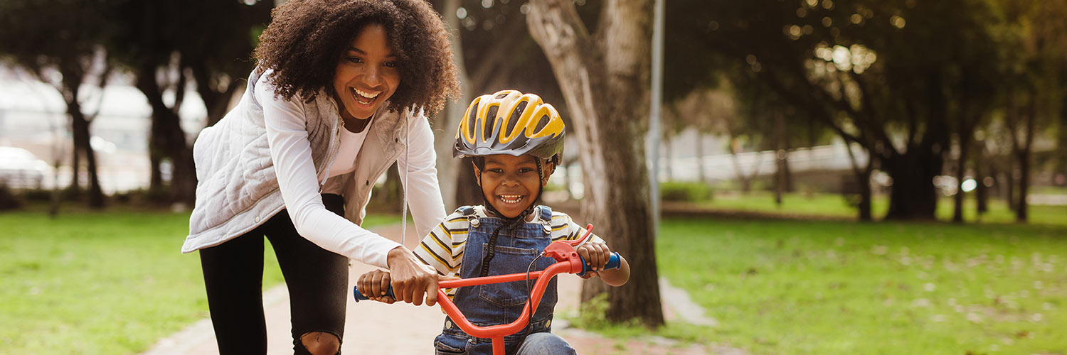 Mother teaching son to ride bicycle