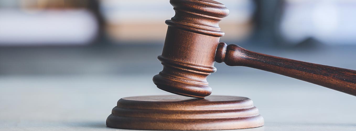 Open books and gavel sitting on a desk.